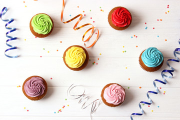 Tasty cupcakes on the wooden table.