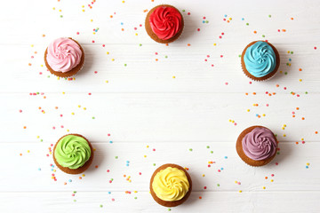 Tasty cupcakes on the wooden table.
