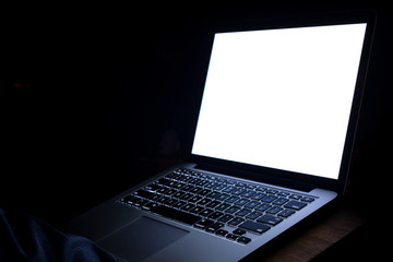 A man hand using laptop with blank screen at night. bedtime working concept.
