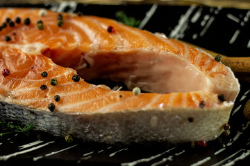 Fresh salmon with spices on a rough wooden background