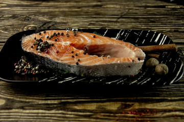 Fresh salmon with spices on a rough wooden background