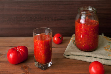 Homemade rustic prepared preserving of fermented vegetables in jar with glass of juice and red...
