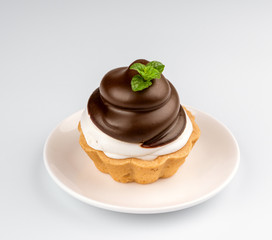 Small chocolate tart with whipped cream on white background