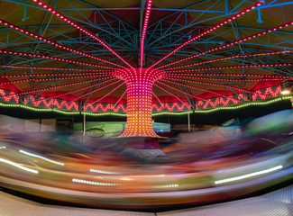 view of a giant ferris wheel attraction in long exposure full of colors at night