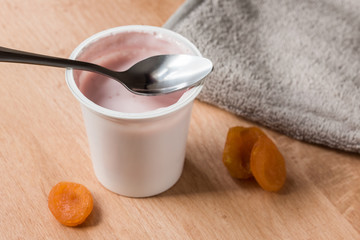 Fruit yogurt in a plastic cup on the kitchen table