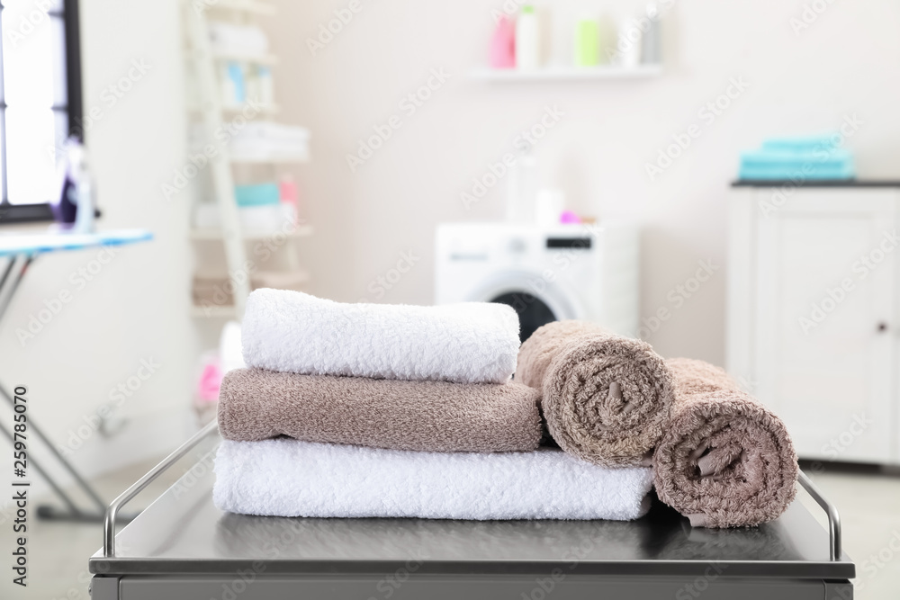 Sticker Soft bath towels on table against blurred background