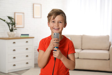 Cute boy with microphone in living room