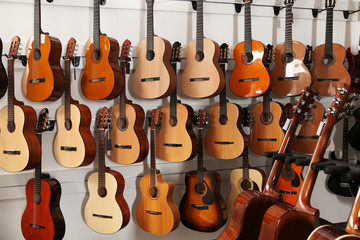 Rijen met verschillende gitaren in de muziekwinkel