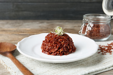 Plate of boiled brown rice served on table