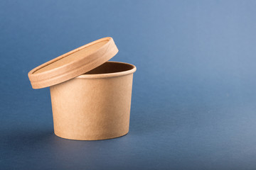 Disposable paper container with cap for soup on a blue background