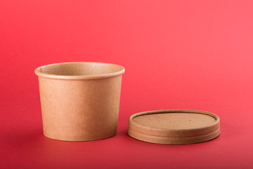 Disposable paper container with cap for soup on a red background