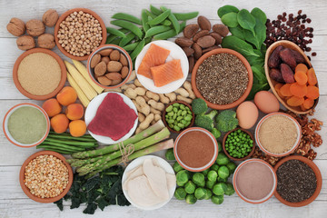 Health food high in protein with meat, fish, dairy, legumes, vegetables, dried fruit, grains, supplement powders, seeds and nuts. Super foods high in dietary fibre, vitamins & antioxidants. Top view.