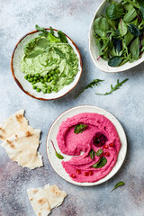 Green pea and pink beet hummus spread or dip with mix salad leaves. Healthy raw summer appetizer, vegan, vegetarian snack.