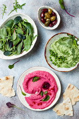 Green pea and pink beet hummus spread or dip with mix salad leaves. Healthy raw summer appetizer, vegan, vegetarian snack.