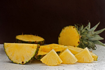 Sliced pineapple on white wooden background. Pineapple Slices of Different Sizes
