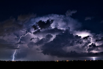 Thunderstorm cloud and lightning strike in the night sky