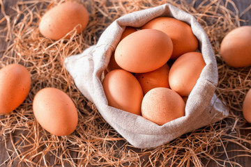 chicken eggs in a canvas bag on straw close-up. background with fresh chicken eggs. the view from the top.
