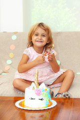 cute girl with a cake unicorn on her birthday