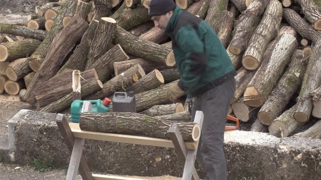 Un particulier tron&ccedil;onne du bois de chauffage