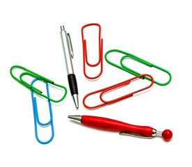 Large multi-colored paper clips and ballpoint pens on a white background the concept of stationery