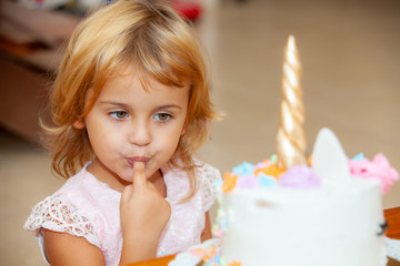 cute girl with a cake unicorn on her birthday