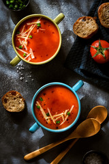 Red vegetarian tomato soup on a dark background, top view. Healthy eating concept