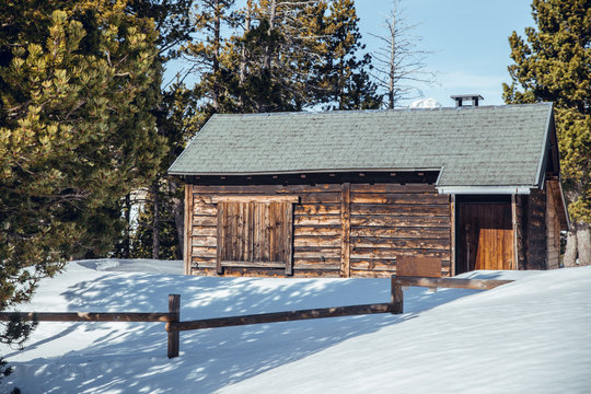 Little old building between snowdrifts and winter forest in sunny day in Cerdanya, France