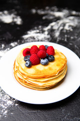 Photo from top of plate with pancakes, blueberries, raspberries