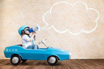 Funny kid driving toy car at home