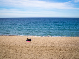 Fototapeta na wymiar Lonely in love couple sitting on the beach in sunny day; copy space