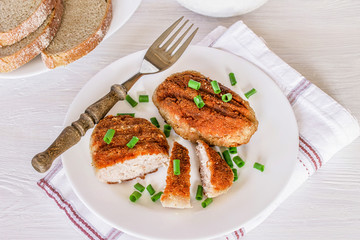cooked cutlets on the table in a plate close-up. ready lunch of fried cutlets and greens.