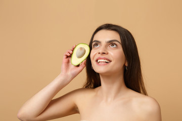 Close up brunette half naked woman 20s with perfect skin nude make up hold avocado isolated on...