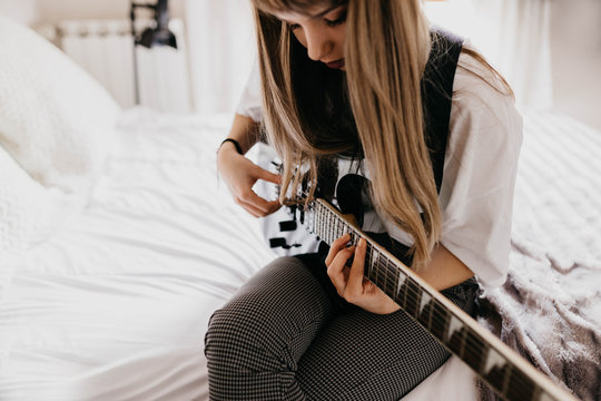 Young brunette woman playing guitar