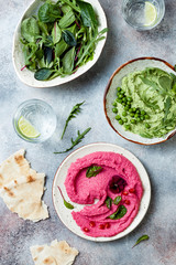 Green pea and pink beet hummus spread or dip with mix salad leaves. Healthy raw summer appetizer, vegan, vegetarian snack.