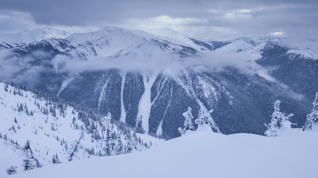 Hills with snow and clouds between mountains 