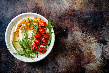 Homemade hummus with roasted cherry tomatoes. Middle Eastern traditional and authentic arab...
