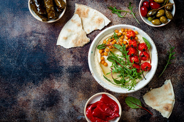Arabic traditional cuisine. Middle Eastern meze with pita, olives, hummus, stuffed dolma, pickles. Mediterranean appetizer party idea