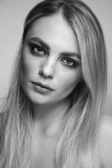 Black and white portrait of young beautiful woman with smoky eye make-up