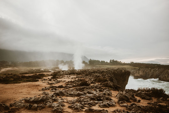 Little crater with smoke between ground and cloudy heaven in Bufones de Pria, Asturias, Spain
