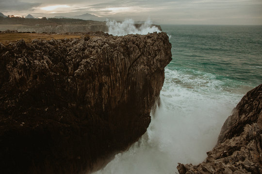 top of stone near stormy sea in Bufones de Pria, Asturias, Spain