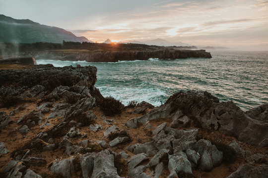top of stone near stormy sea in Bufones de Pria, Asturias, Spain