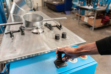 Worker controls the machine. Production rolling tool, electric machine. the production of ventilation and gutters. Tool and bending equipment for sheet metal.