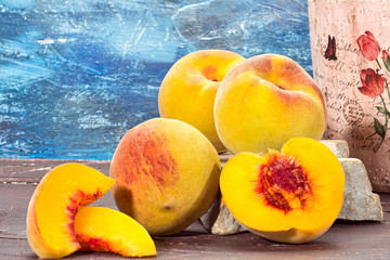 Collection of ripe peaches on wooden table and blue background