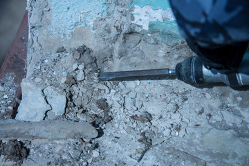 Repair and construction working indoors. Grunge background rubble and stones. Man's gloves with a...