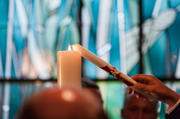 closeup of hand and candle in church