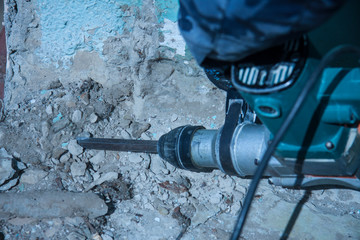 Repair and construction working indoors. Grunge background rubble and stones. Man's gloves with a...
