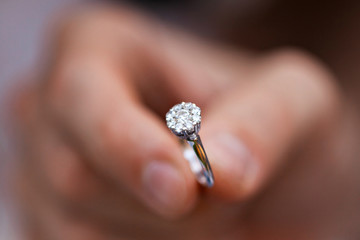 Close-up of a ring in a mans hand. young man giving engagement ring to his girlfriend. Man making marriage proposal to his beloved woman. Romantic date. - obrazy, fototapety, plakaty
