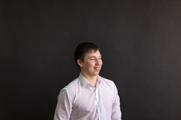 young man in white shirt on dark background