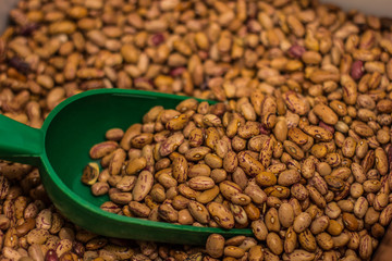 brown haricot beans food background supermarket counter concept with green spoon by weight