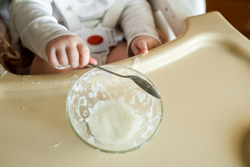 Happy cute infant baby boy spoon eats itself